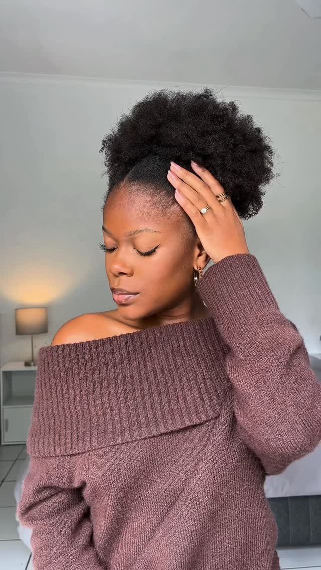 Woman with voluminous natural hair gathered into a high puff