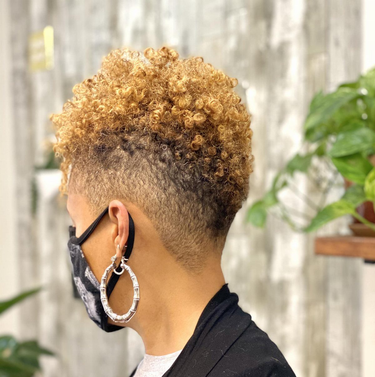 Short golden-brown curls rise above closely cropped sides