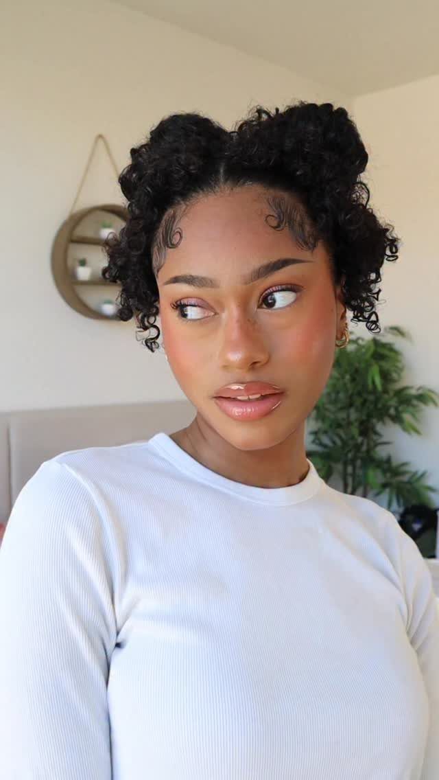 Person wearing curly hair in two high space buns indoors
