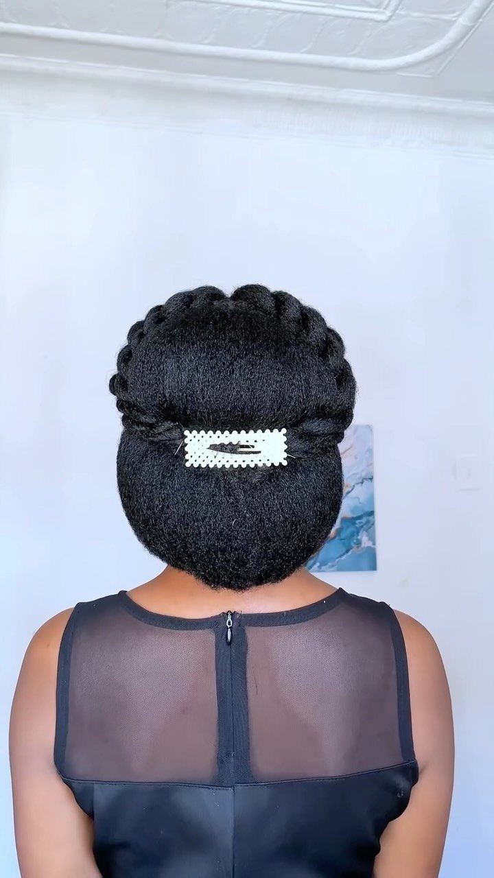 Black twisted updo secured with a white clip, viewed from behind