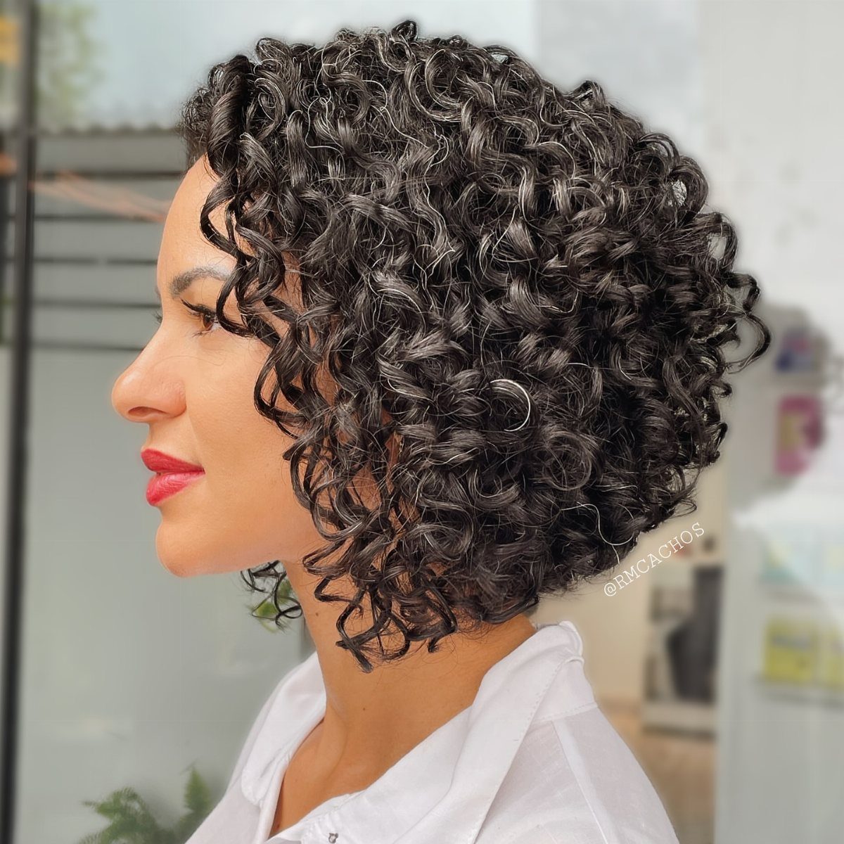 Woman wearing a chin-length bob with dense, defined dark ringlets