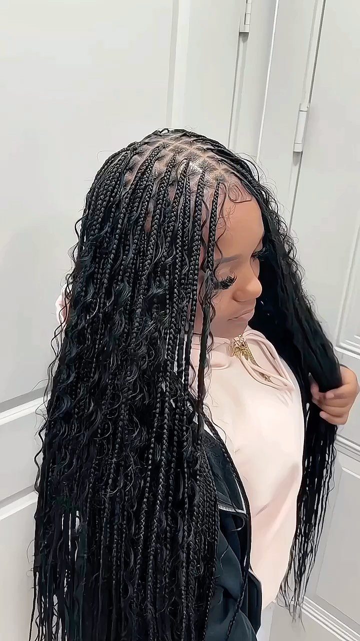Long black knotless braids with loose boho waves on a side-profile person