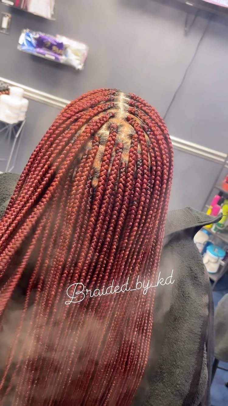 Long burgundy small box braids arranged in neat grid-patterned sections
