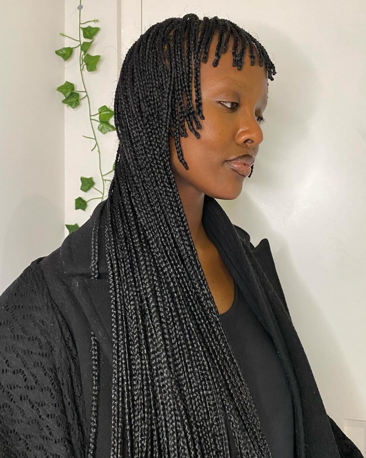 Woman wearing long, thin black box braids with short side-swept bangs