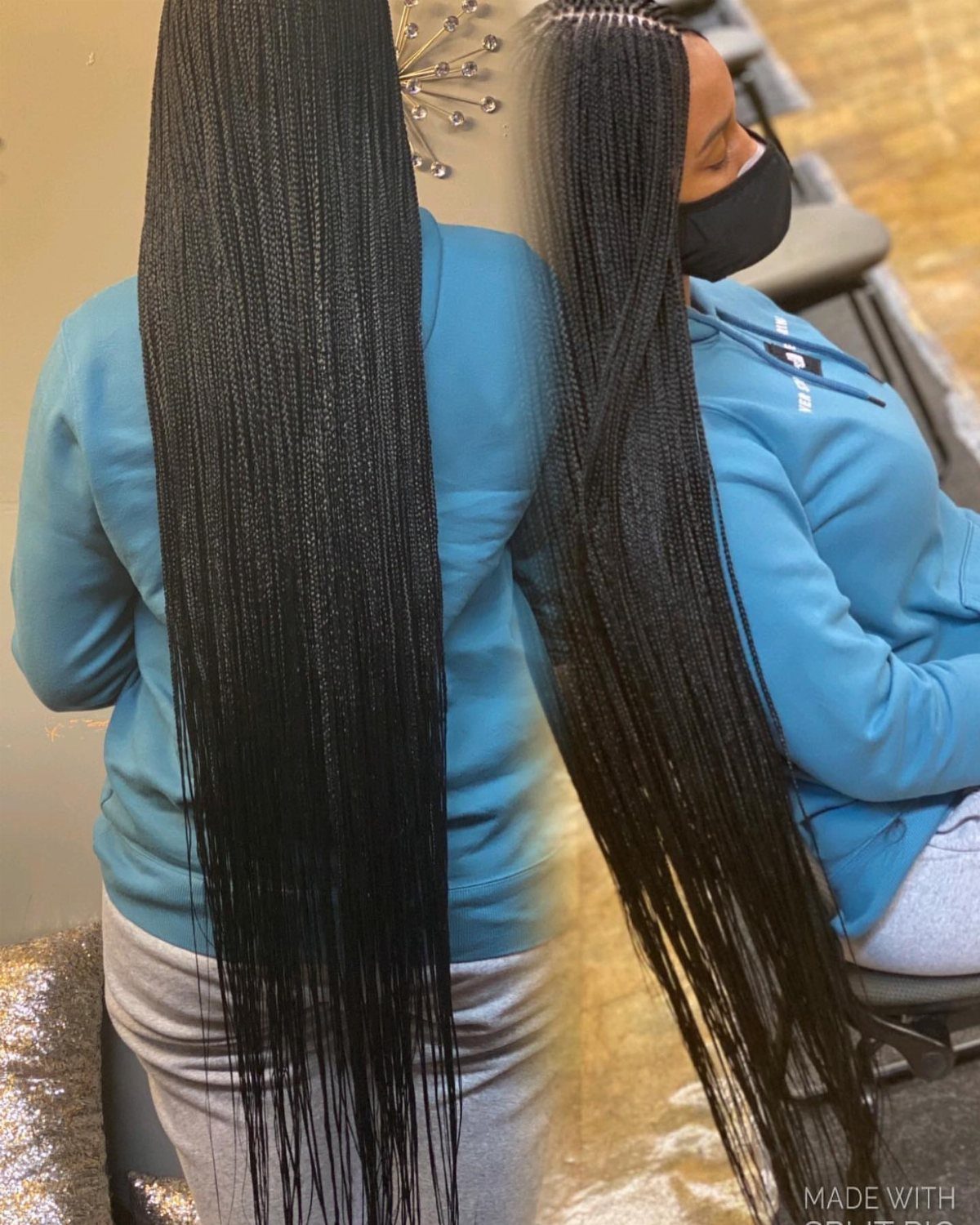 Long thin black braids hang past the waist toward the thighs