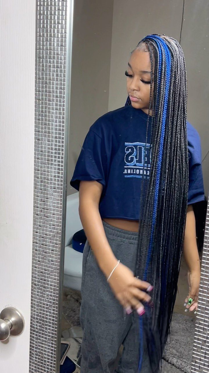 Long black braids with bright blue highlight sections fall past a woman's waist