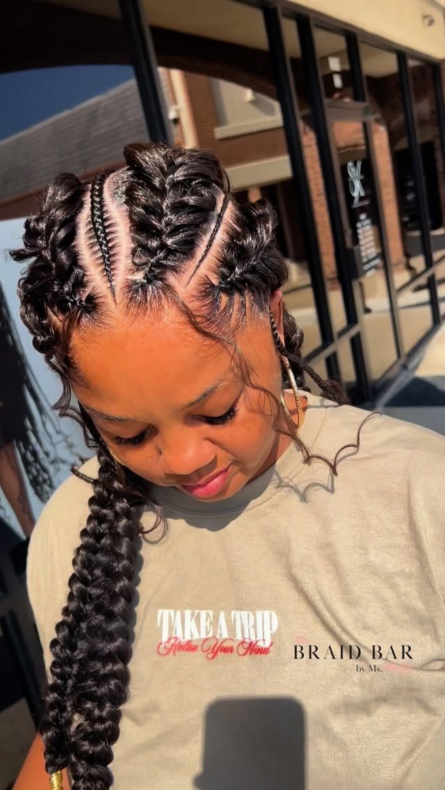Black braids styled in cascading loops across the scalp and a thick side braid