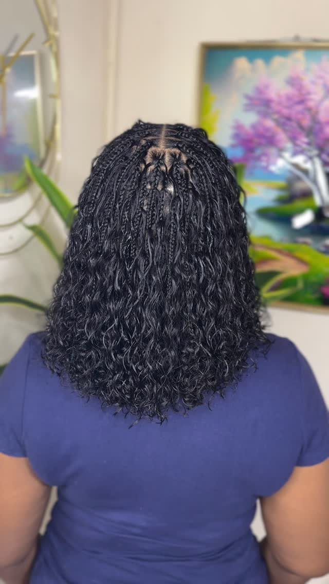 Black shoulder-length small braids with curly ends shown from behind