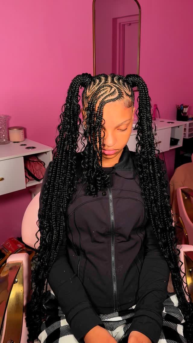 Long black braided pigtails with curled ends on a seated person in a salon