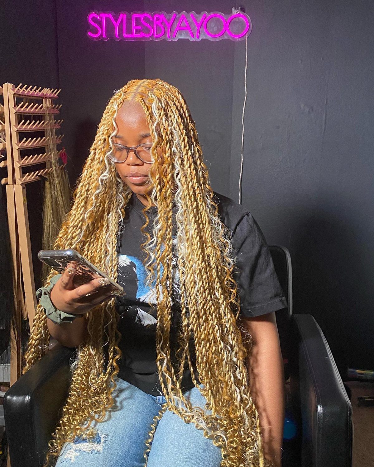Person wearing very long bright blond Marley twists while seated in a salon chair