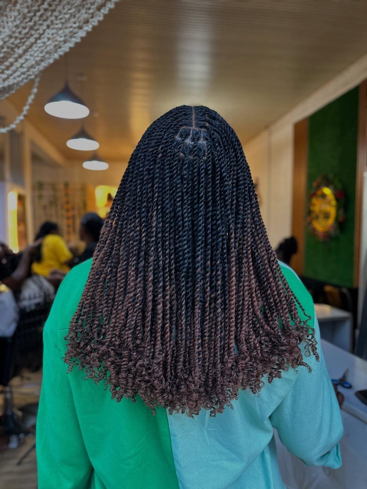 Long dark Marley twists with subtle reddish-brown strands and curly ends in a salon