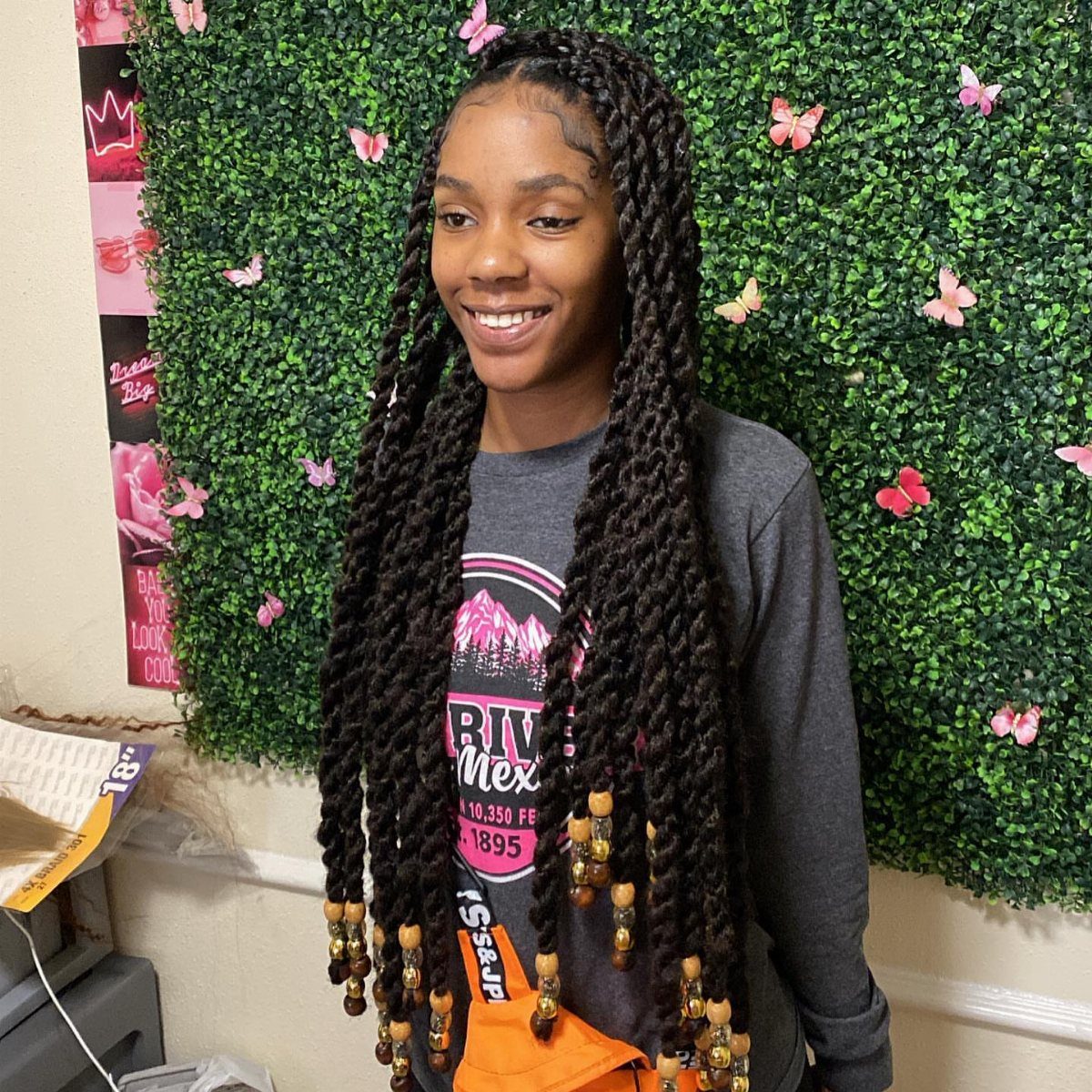 Woman wearing extra-long Marley twists decorated with wooden and golden beads