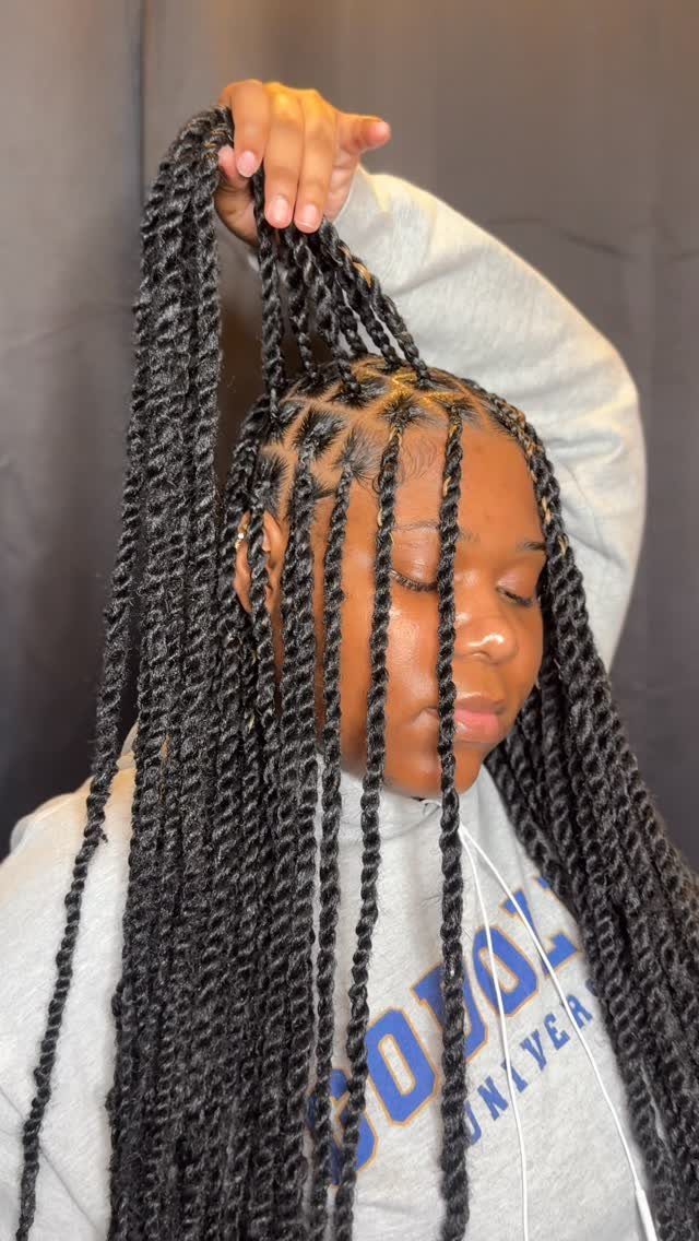 Long black Marley twists reveal varied geometric partings across the scalp