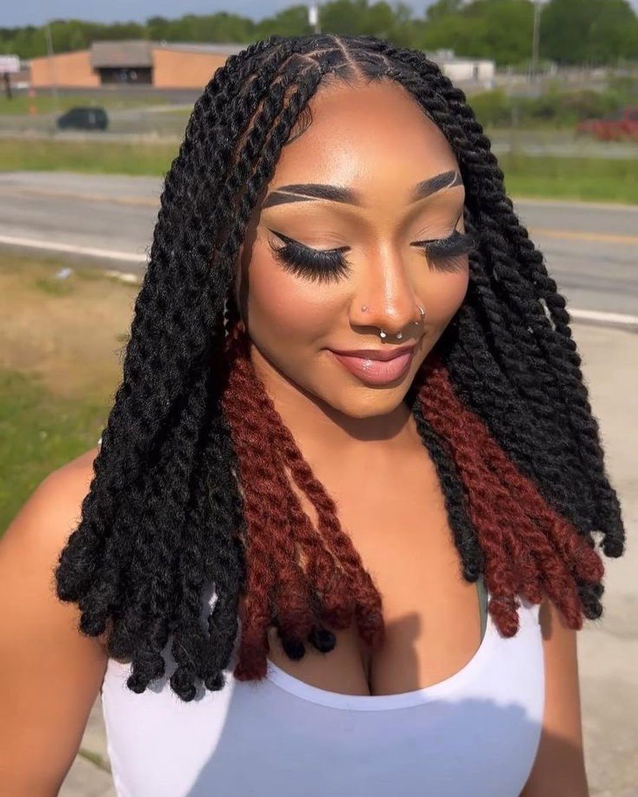Woman showing shoulder-length black and reddish-brown Marley twists outdoors