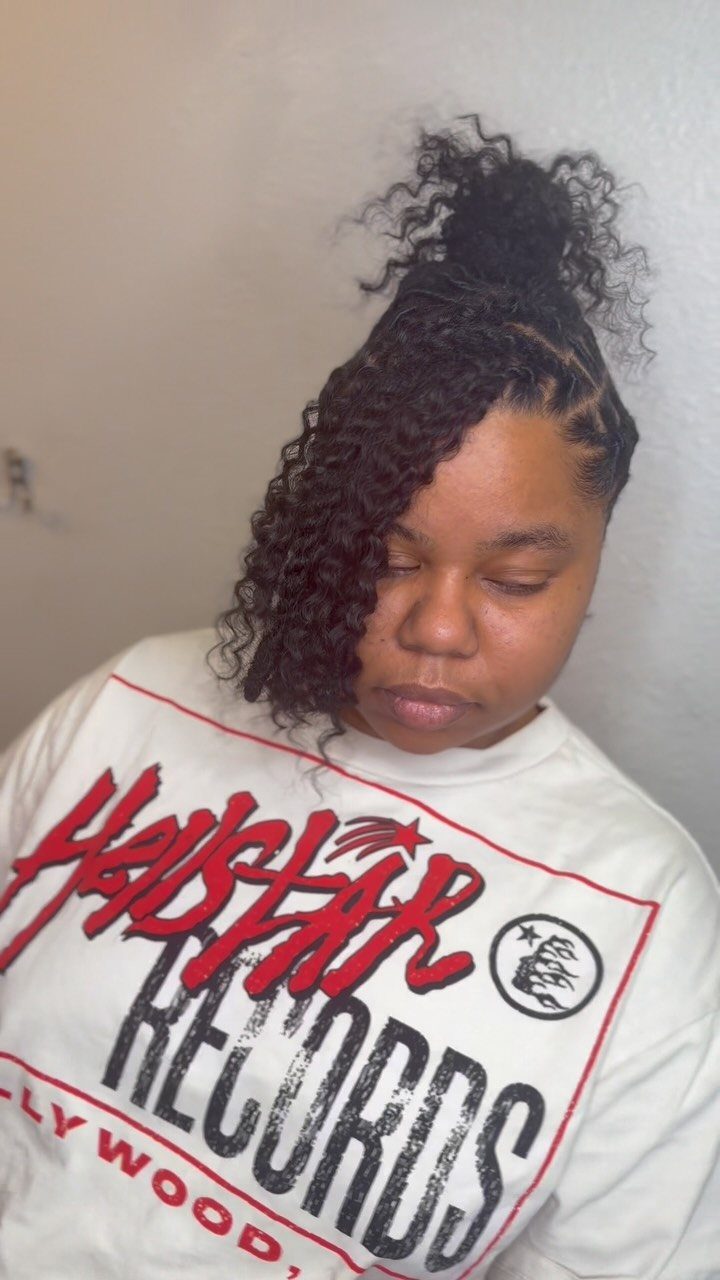 Person wearing dark Marley twists in a high bun with side-swept twists