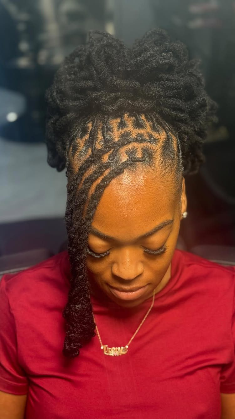 Woman with dark Marley twists gathered into a high updo and one twist hanging forward