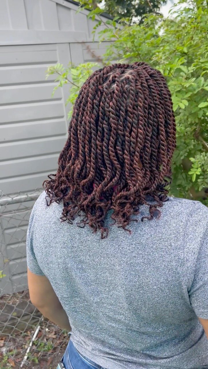 Dark Marley twists fall just below the shoulders on a person outdoors