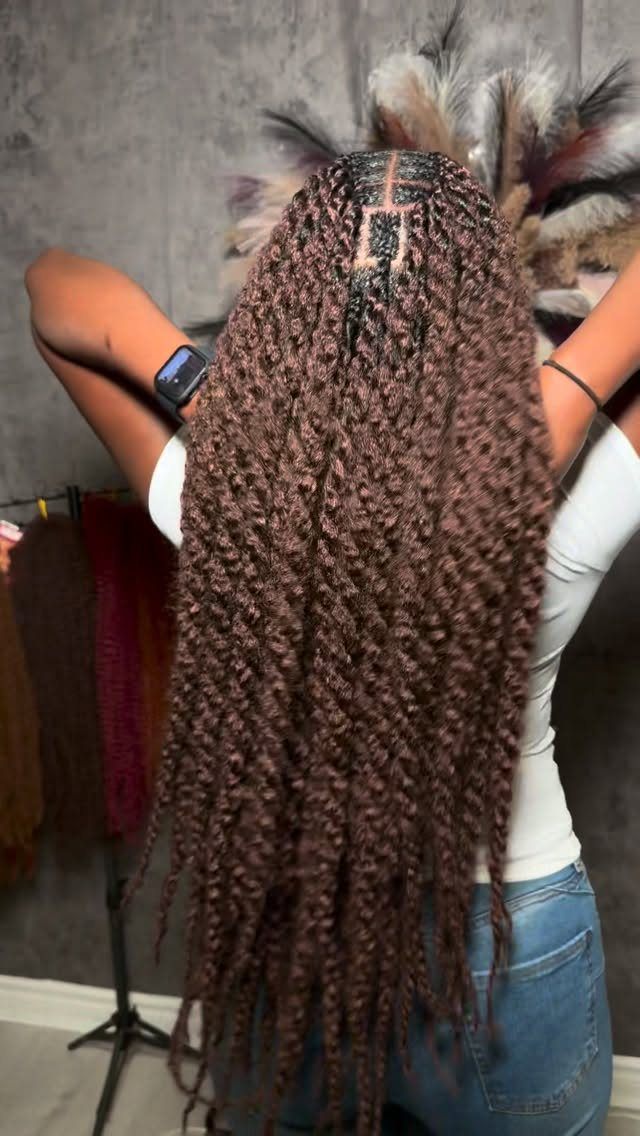 Long medium-sized brown Marley twists fall down a person's back