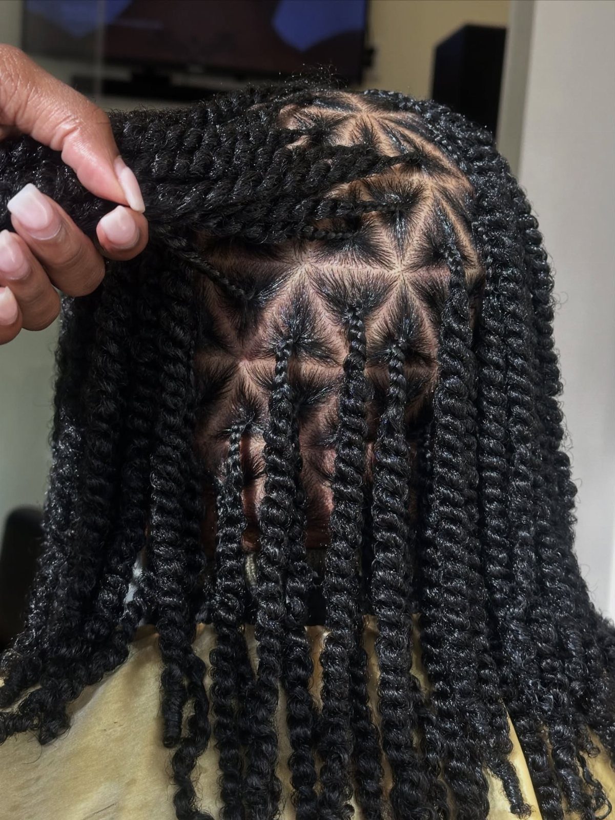 Black Marley twists with neat triangular partings, lifted to reveal the scalp sections