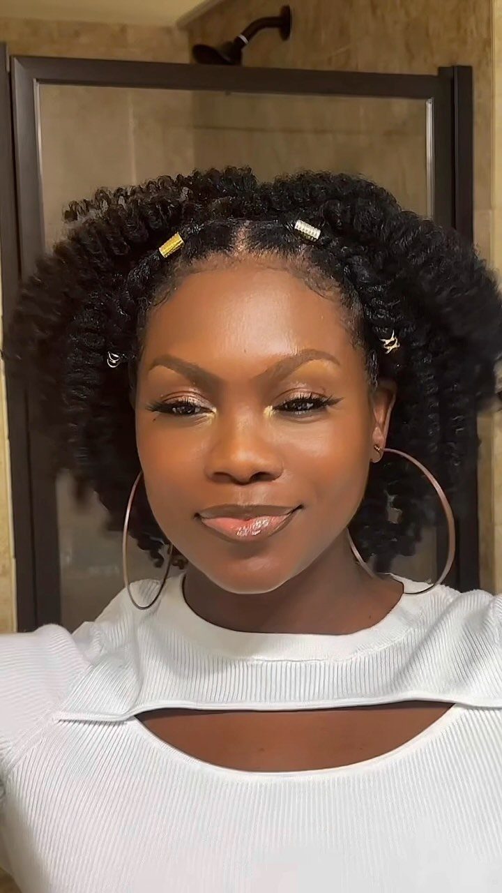Woman wearing voluminous curly twists decorated with small metallic hair cuffs