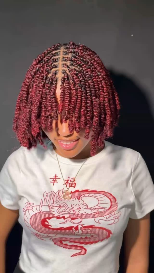 Person with burgundy mini twists arranged into a short bob hairstyle