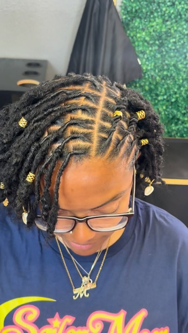 Chunky twists with gold cuffs and a center part on natural hair