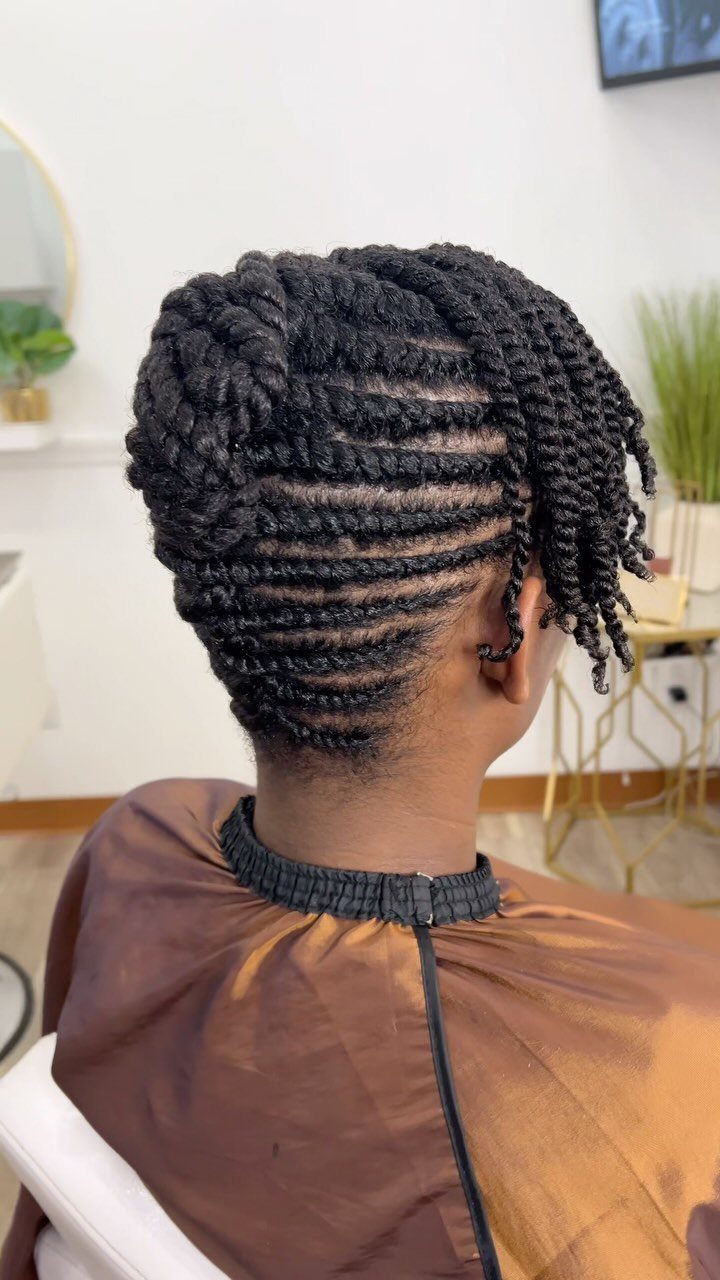 Black flat twists gathered into a rounded low updo at a salon