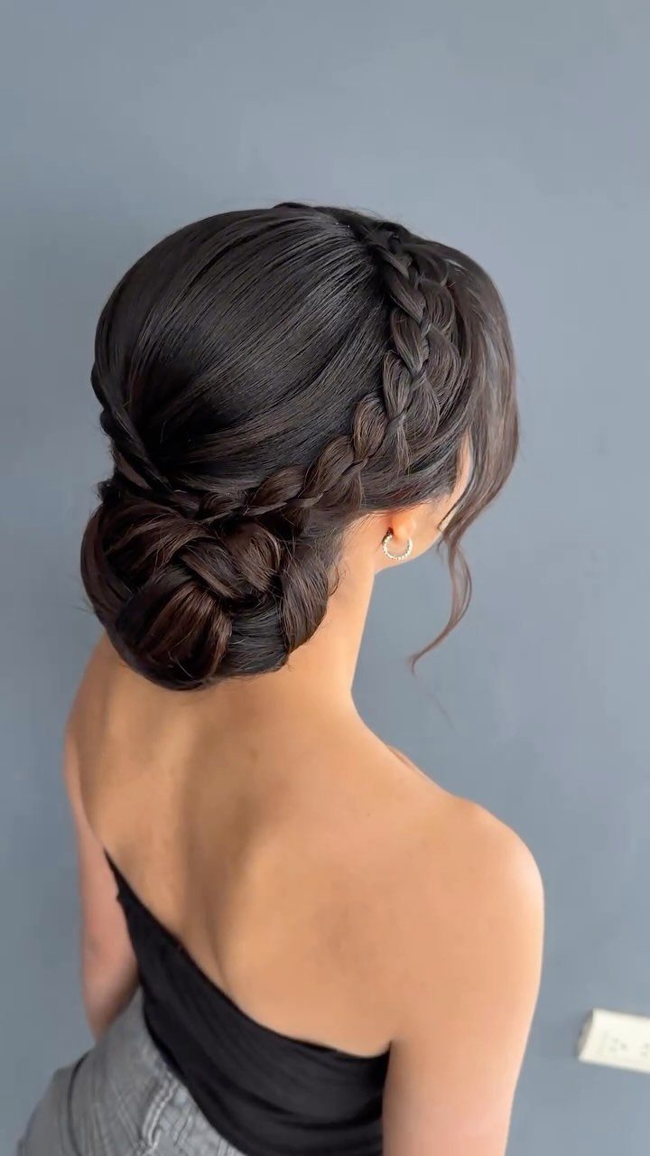 French crown braid wrapped into a low braided bun on a woman