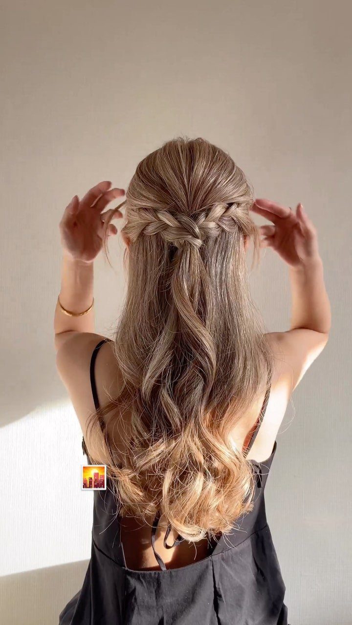 Long brown hair styled in a half-up Y-shaped braid with loose waves
