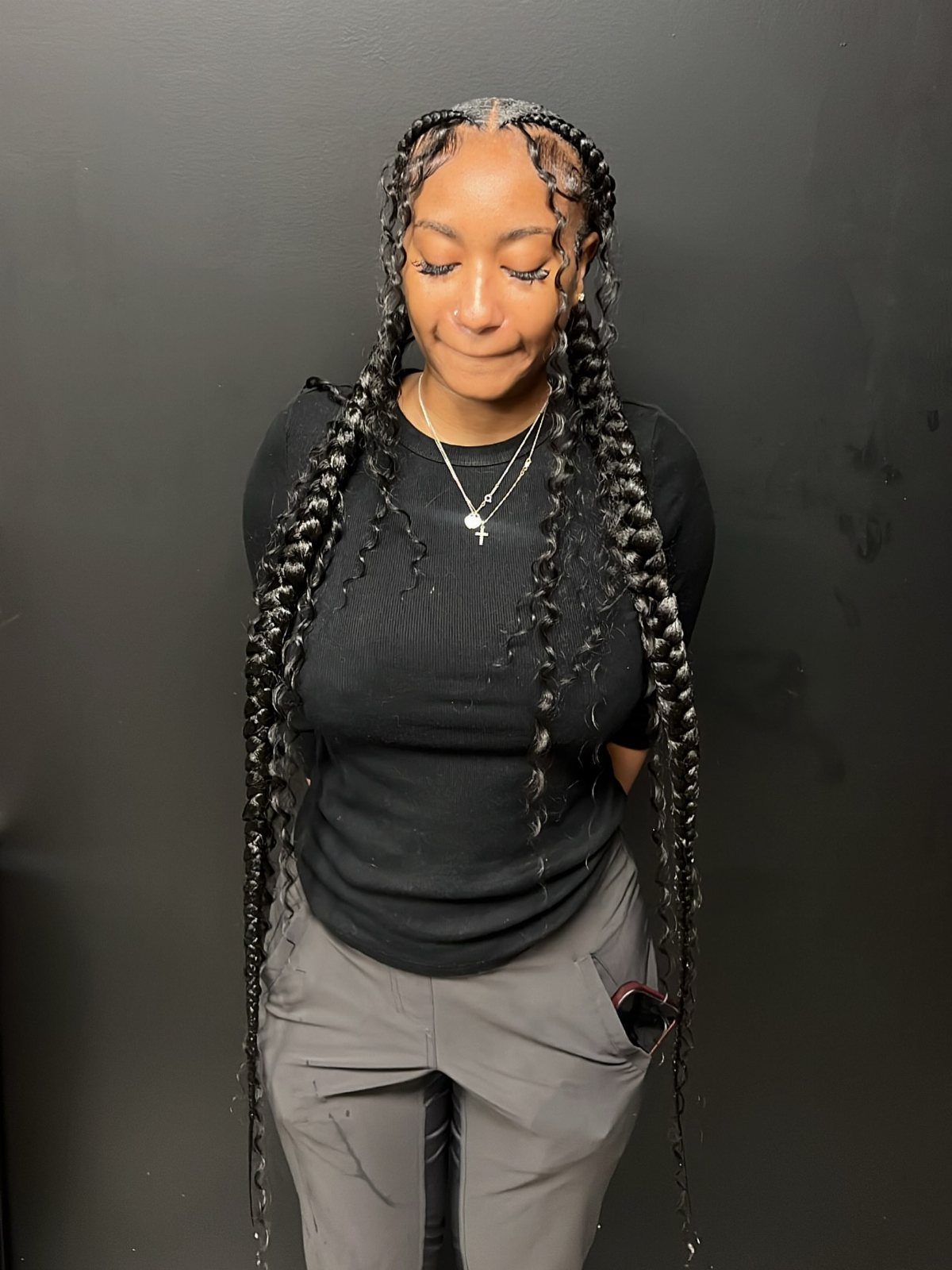 Woman wearing two long braids with loose curls framing her face