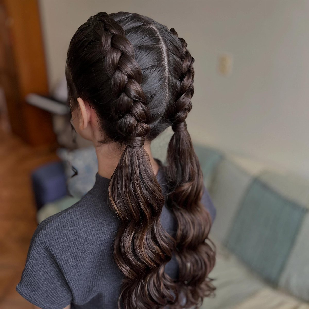 Back view showing two thick French braids with long wavy ponytails