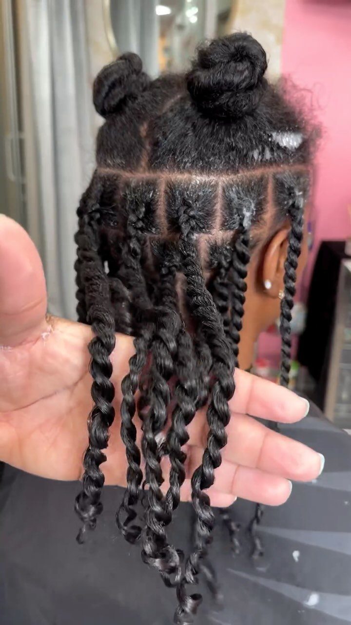 Two-strand twists hang from sectioned hair with curled ends
