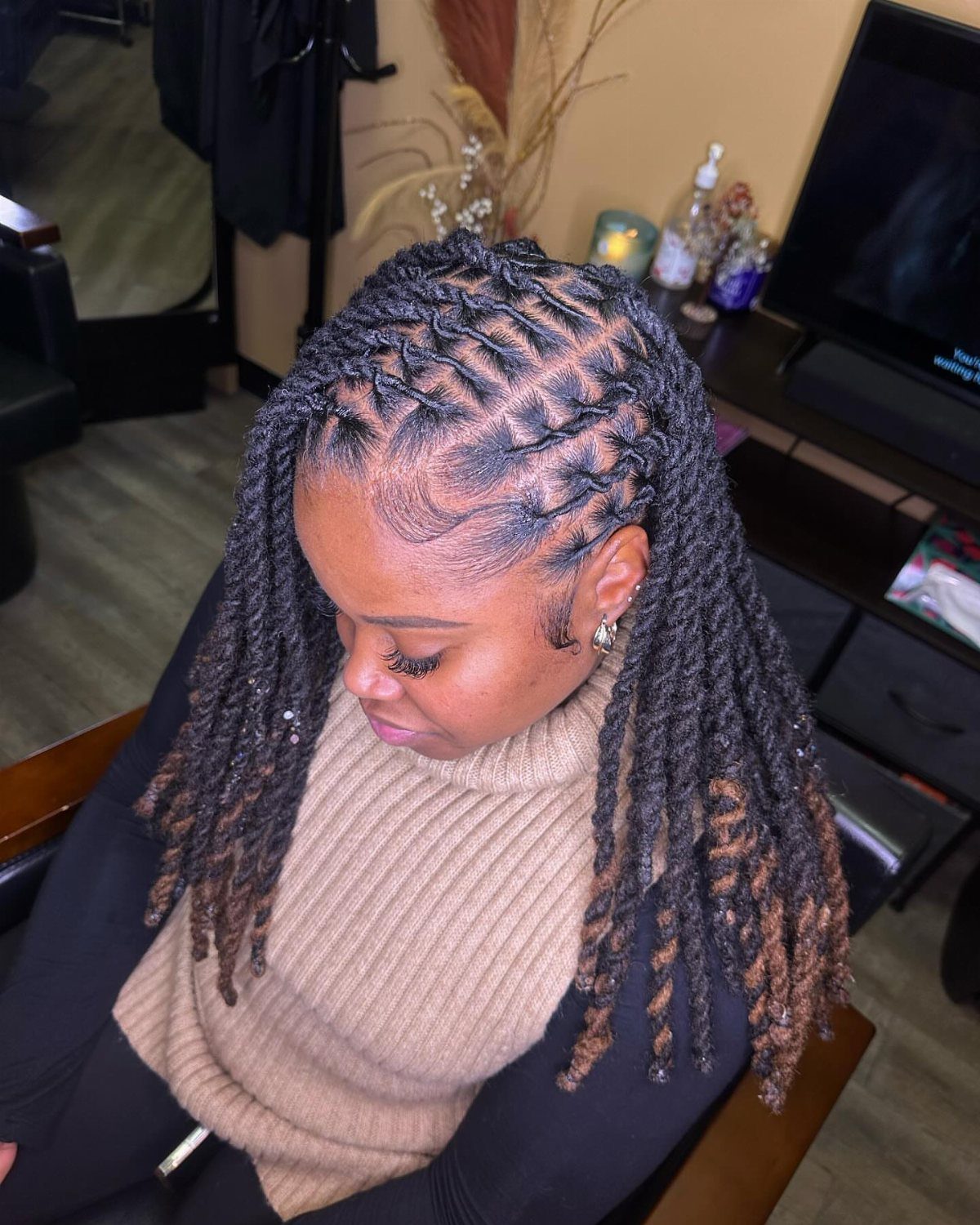 Long two-strand twists sweep from a deep side part in curved rows