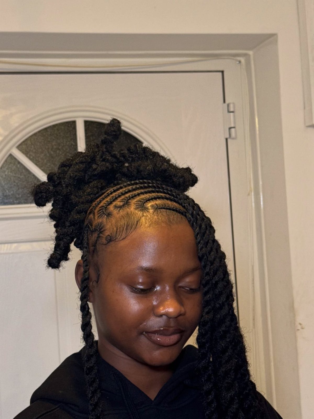 Thick natural twists sweep across one side of a person's face