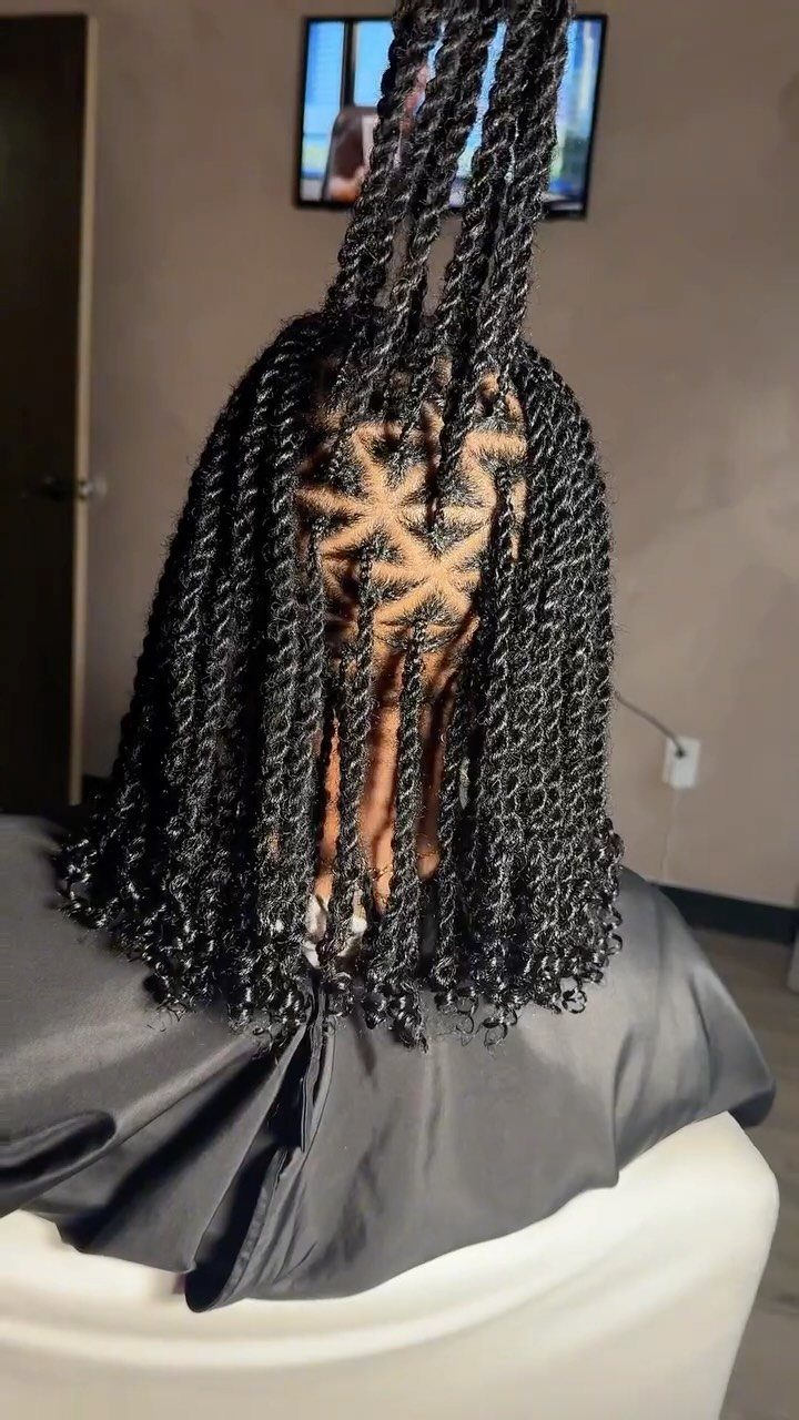 Long black twists reveal neat geometric square and triangular scalp partings