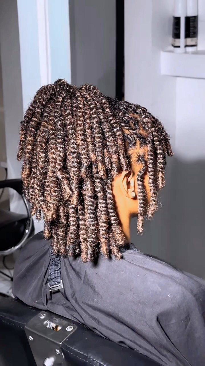 Shoulder-length two-strand twists arranged in straight-back rows on a salon client