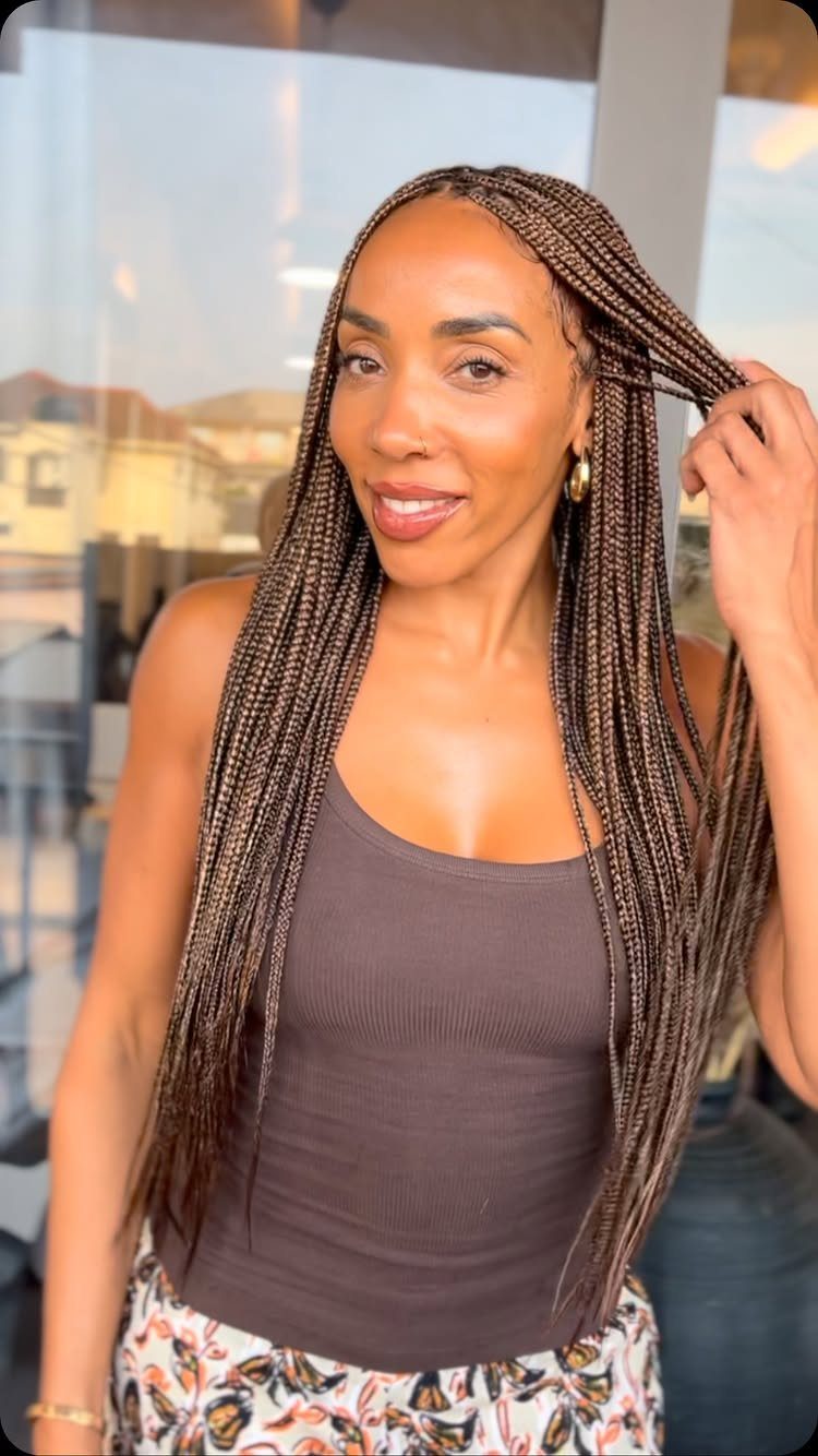 Woman displays long, thin dark braids parted into small sections