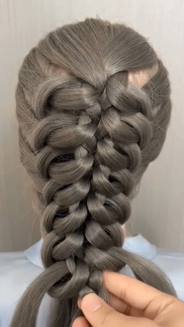 Voluminous ash-brown braid with cascading loops held at the ends