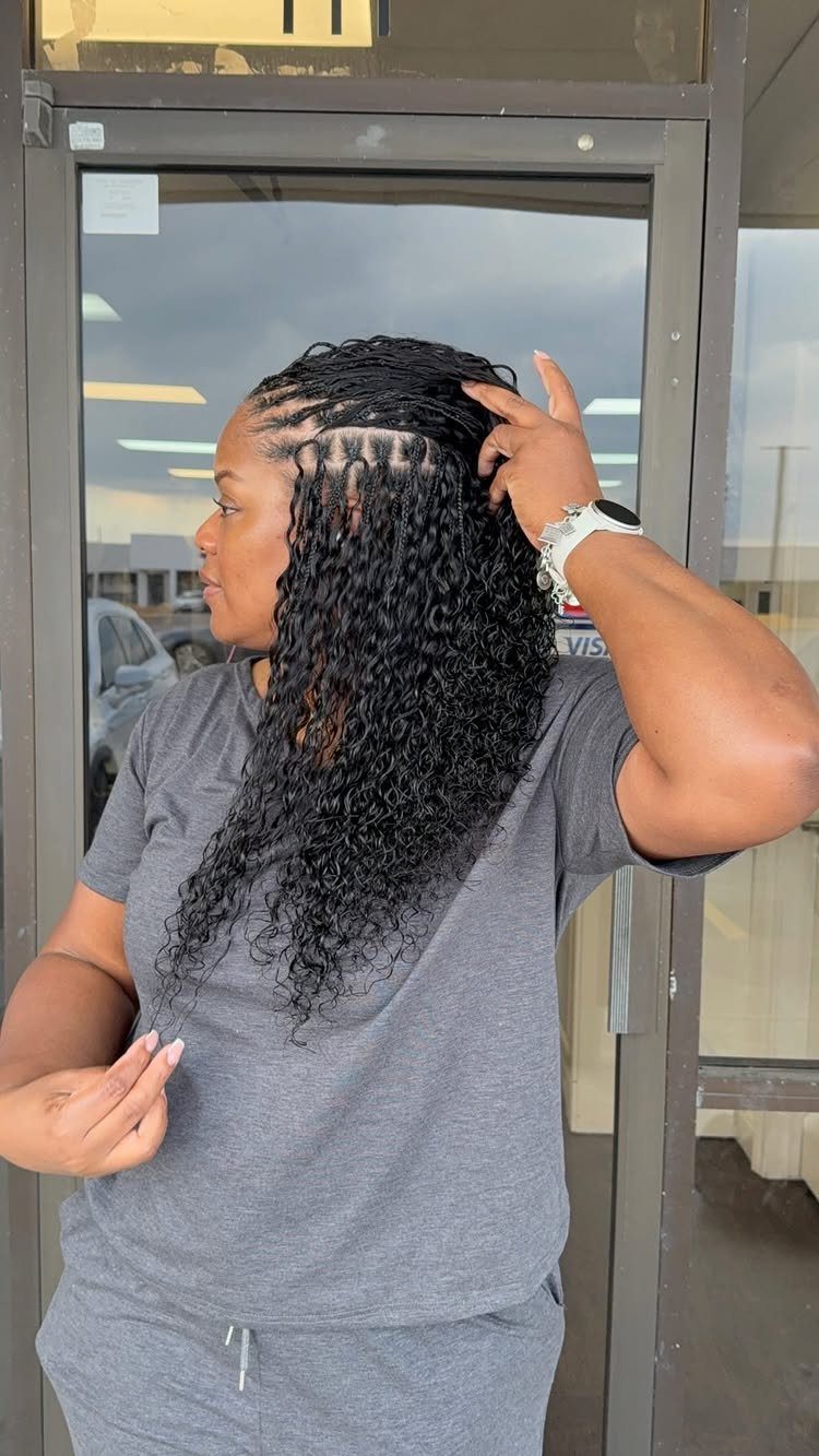 Woman displaying numerous fine individual braids flowing into long dark curls