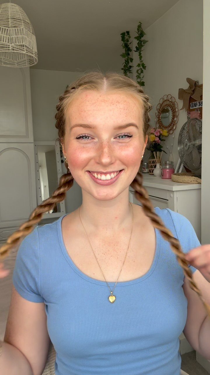 Woman with two long brown rope braids over her shoulders