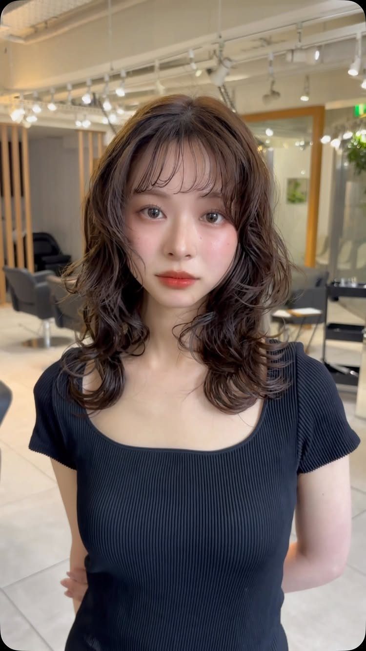 Woman showing medium-length layered waves with wispy French-girl-style bangs