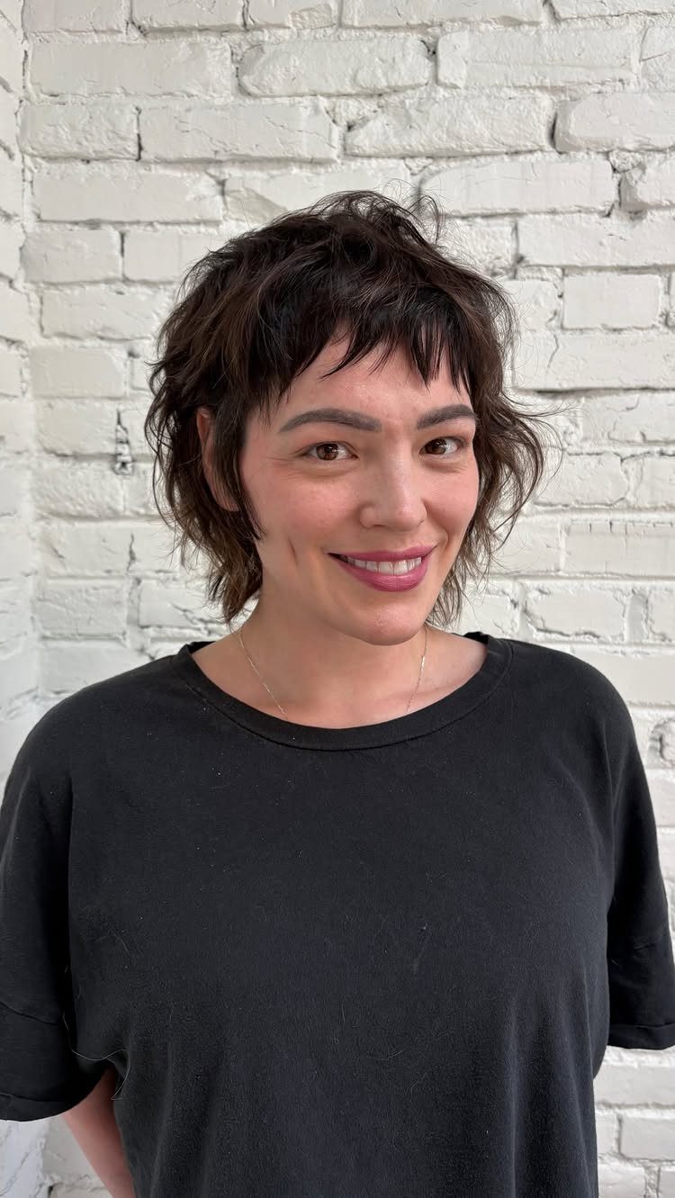 Person showcasing a short shaggy bob with choppy layers and wispy bangs