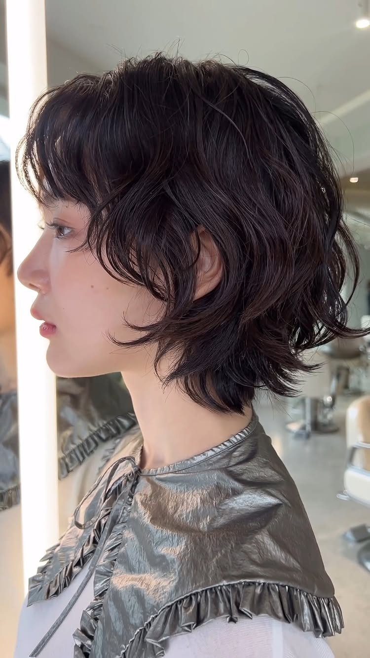 Dark layered wolf cut with shorter crown and longer wavy pieces at the back
